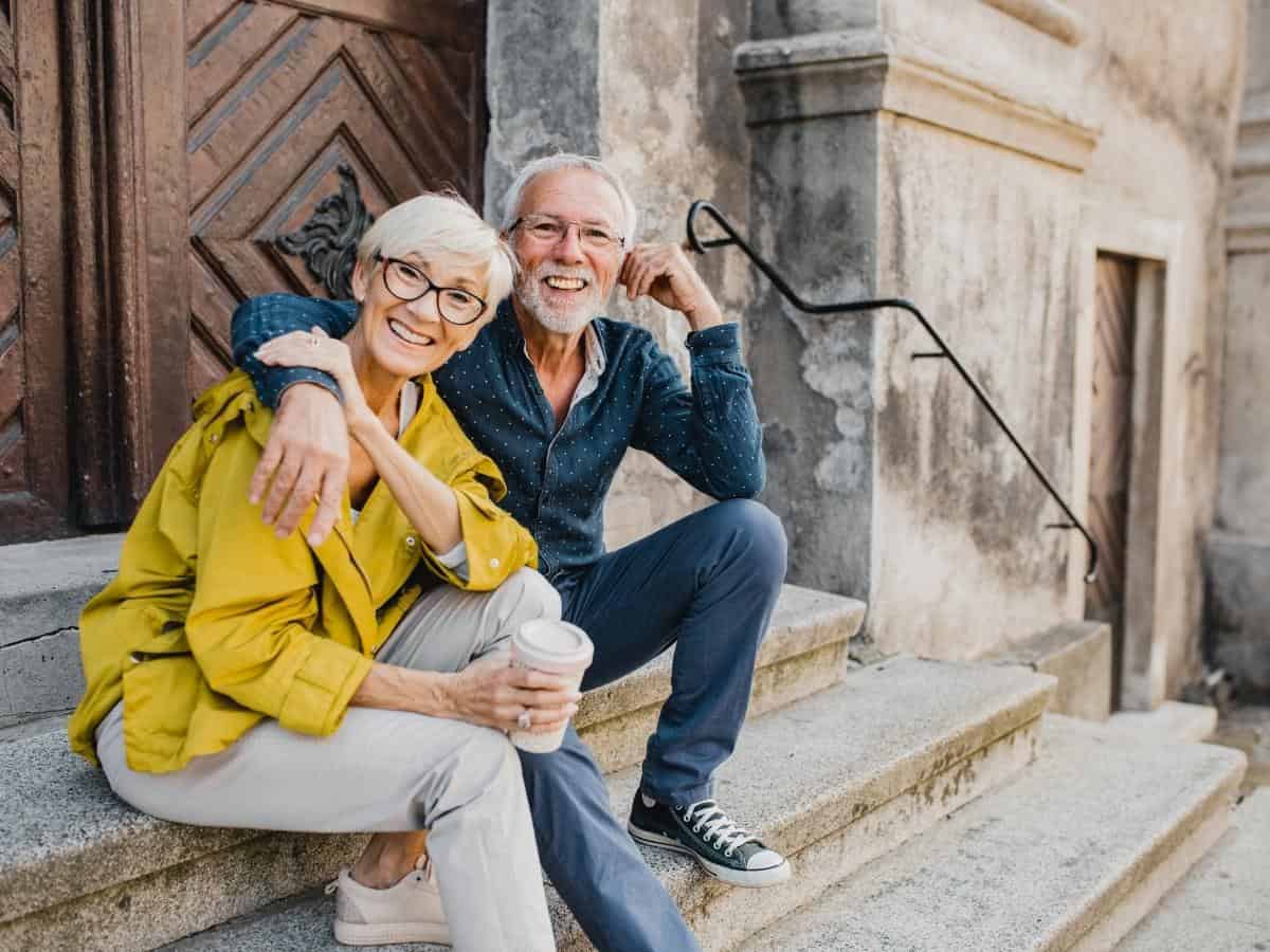 Senior couple sitting on church steps in Europe