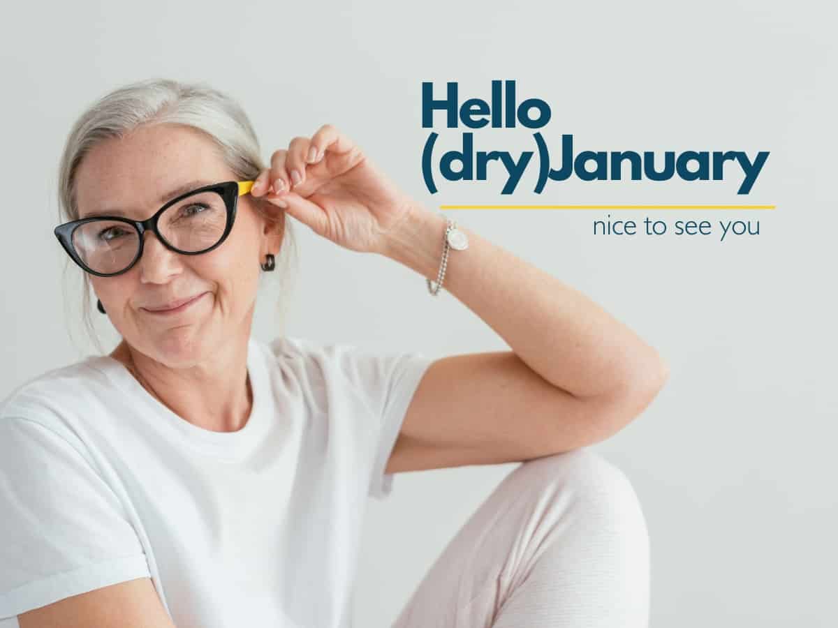 Older attractive woman with grey hair wearing colorful eyeglasses and smiling