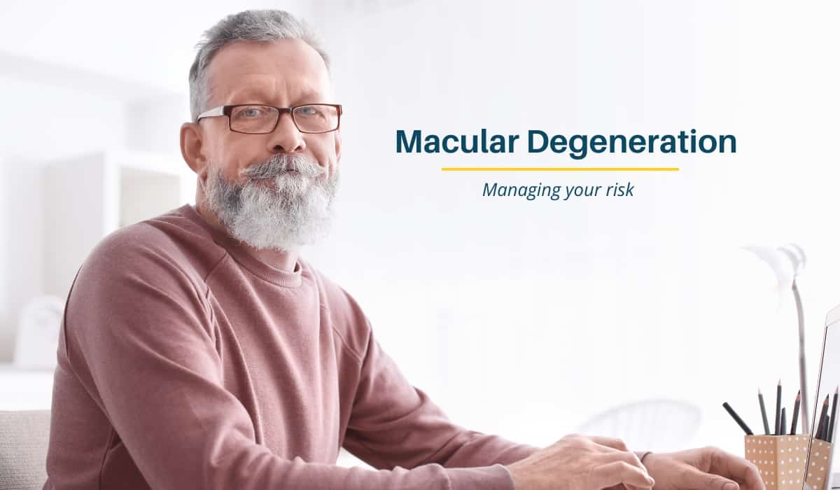 Grey haired man wearing glasses searching for information on Macular Degeneration on a laptop computer