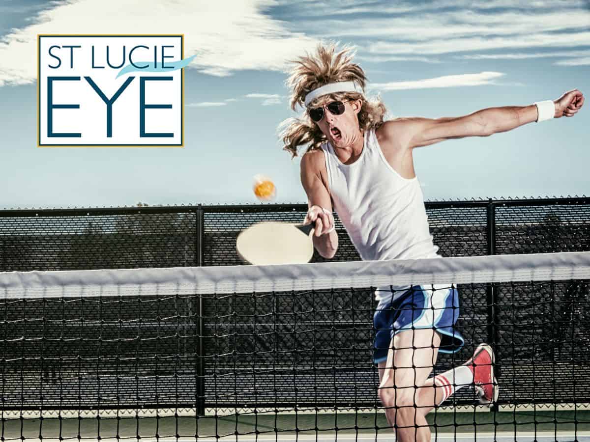Man with a mullet playing pickleball in sunglasses, exuding style and humor on the court