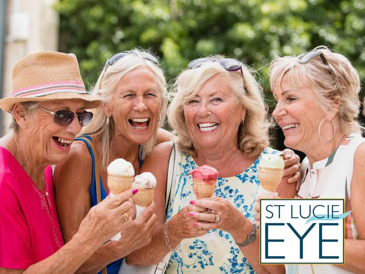 Four women smiling and eating ice cream
