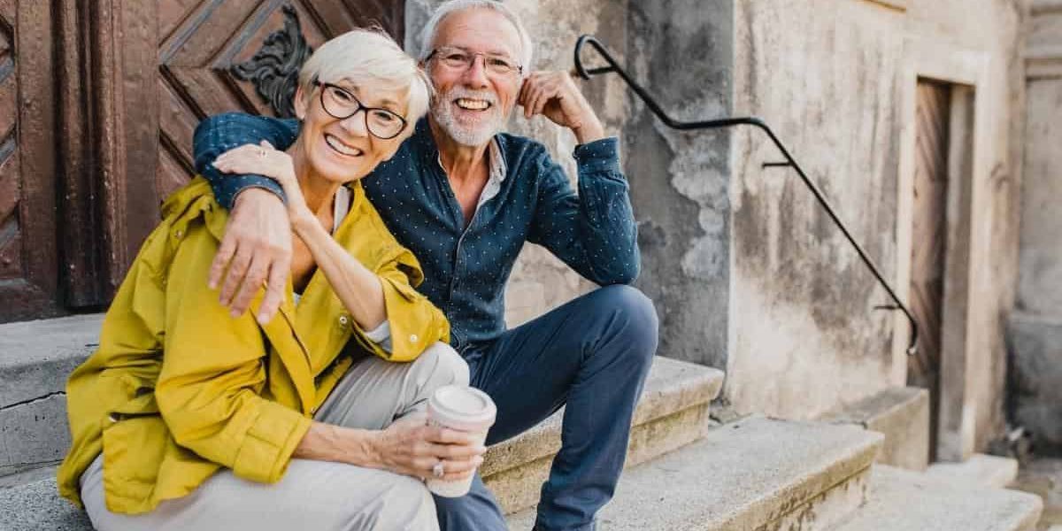 Senior couple sitting on church steps in Europe
